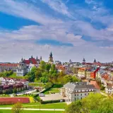Widok na miasto z kolorowymi kamienicami i kościołami, zielonymi wzgórzami i boiskiem sportowym. Lubelszczyzna atrakcje zachwycają!