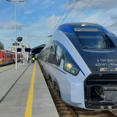 Nowoczesny pociąg Pendolino ED161 "Chrobry" na stacji. Obok stoi czerwony pociąg regionalny.