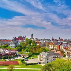 Widok na miasto z kolorowymi kamienicami i kościołami, zielonymi wzgórzami i boiskiem sportowym. Lubelszczyzna atrakcje zachwycają!