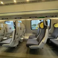 Wnętrze pociągu z wygodnymi fotelami. Czy to EIP? Tak, to nowoczesny pociąg, który zabierze Cię w podróż.