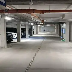 Wrocław Główny parking cennik: podziemny parking z samochodami, rurami i motocyklem w oddali.