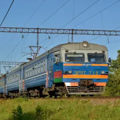 Pociąg elektryczny jedzie po torach, a nad nim widać sieć trakcyjną. To idealny sposób, jak dojechać pociągiem do Kamienia Pomorskiego.
