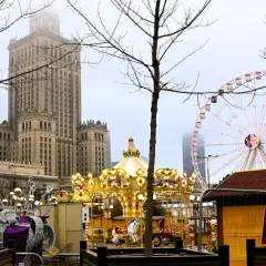 Złota karuzela i diabelski młyn na jarmarku świątecznym Warszawa. W tle Pałac Kultury i Nauki.