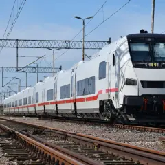 Biały pociąg z czerwonym pasem, gotowy do podróży. To może być nasz Berlin Express, czekający na pasażerów.