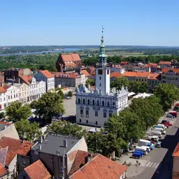Widok na rynek z ratuszem i wieżą, w tle kościół i ceglana wieża. Miasto przypomina trochę Bydgoszcz, ale to urokliwa Brodnica.