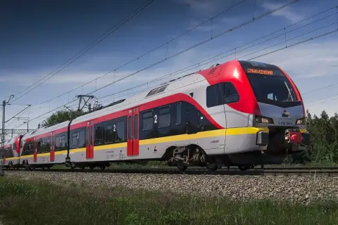 Nowy pociąg PKP Intercity "Łódź Kaliska-Kołobrzeg" pędzi po torach, mijając zielone drzewa.