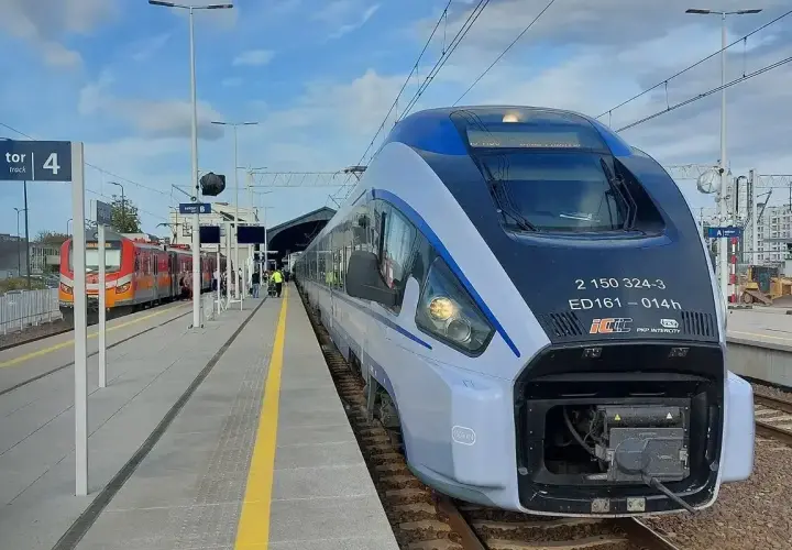 Nowoczesny pociąg Pendolino ED161 "Chrobry" na stacji. Obok stoi czerwony pociąg regionalny.