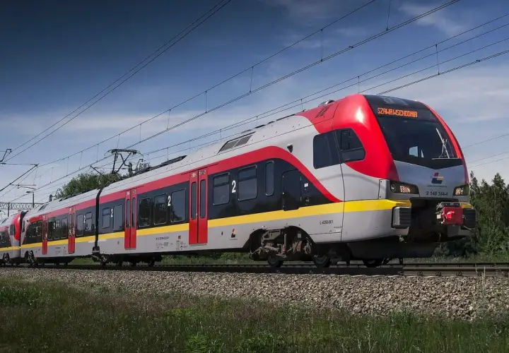 Nowy pociąg PKP Intercity "Łódź Kaliska-Kołobrzeg" pędzi po torach, mijając zielone drzewa.
