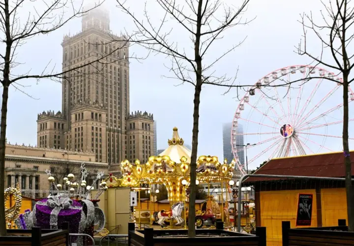 Złota karuzela i diabelski młyn na jarmarku świątecznym Warszawa. W tle Pałac Kultury i Nauki.