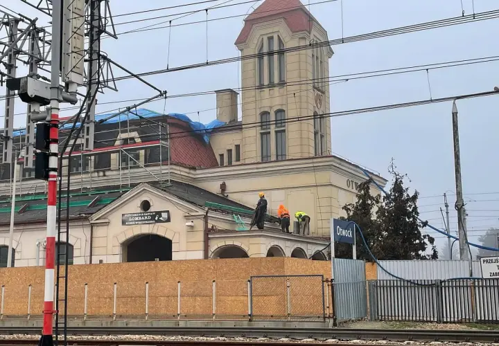 Prace remontowe na dachu dworca PKP Otwock. Pracownicy w kamizelkach odblaskowych i kaskach wykonują prace.
