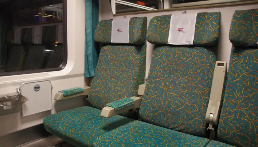 Wnętrze wagonu Intercity z wygodnymi siedzeniami. Numeracja 44 i 46 pomaga znaleźć wagon.