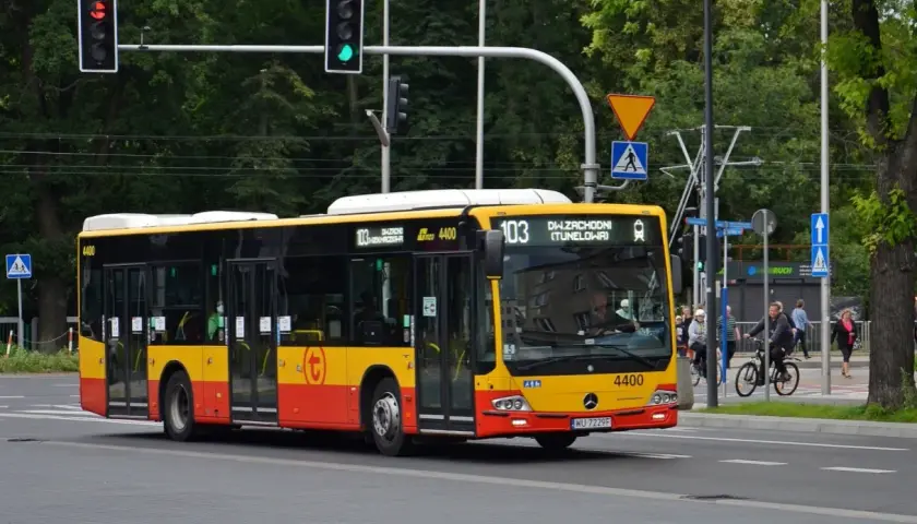 Autobus linii 103 w Warszawie, żółto-czerwony, jedzie ulicą. Na wyświetlaczu widnieje "DW. ZACHODNI (TUNELOWA)".