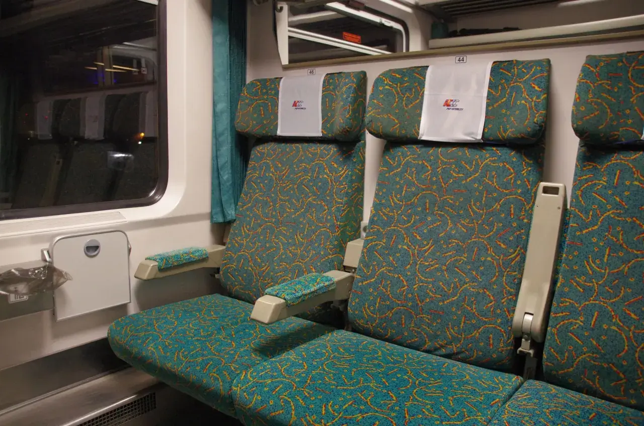 Wnętrze wagonu Intercity z wygodnymi siedzeniami. Numeracja 44 i 46 pomaga znaleźć wagon.