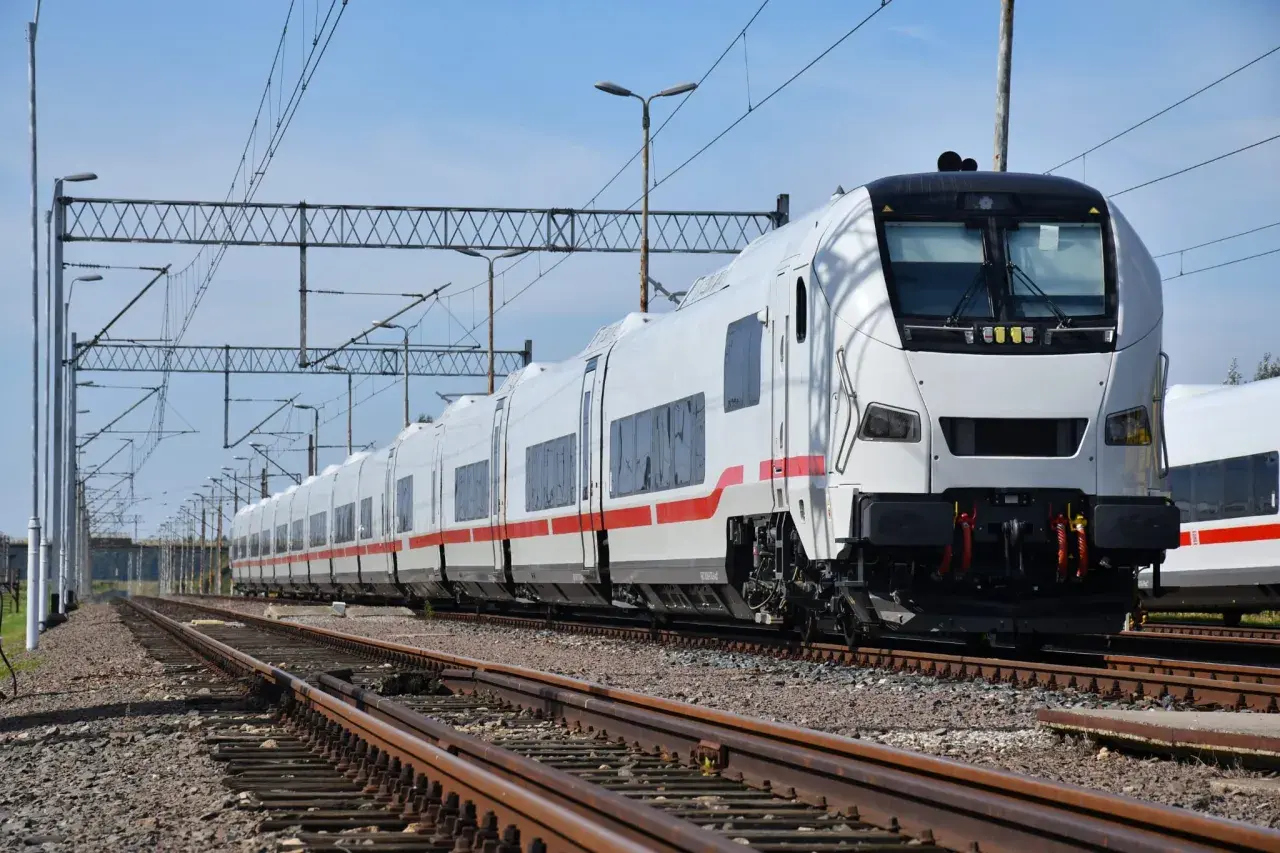 Biały pociąg z czerwonym pasem, gotowy do podróży. To może być nasz Berlin Express, czekający na pasażerów.