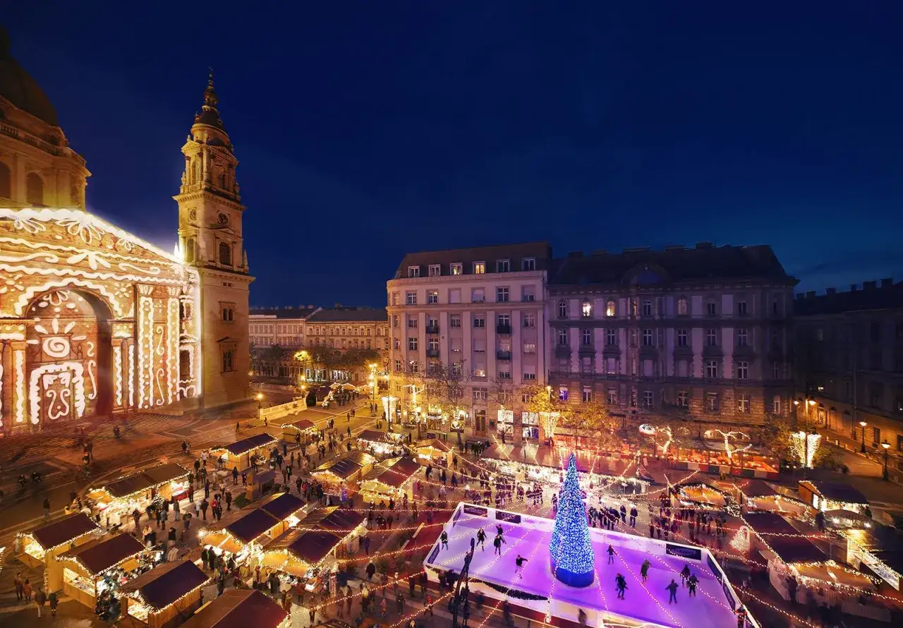 Magiczny budapeszt jarmark bożonarodzeniowy. Bazylika ozdobiona światłami, lodowisko, choinka i mnóstwo straganów tworzą świąteczną atmosferę.
