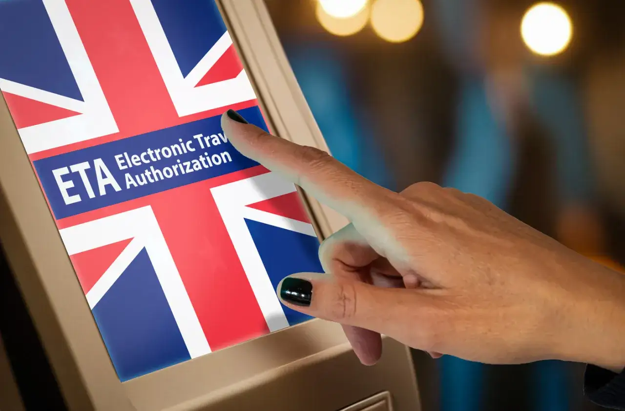 Palec dotyka ekranu z flagą Wielkiej Brytanii i napisem ETA. Czy do Londynu trzeba paszport? Sprawdź ETA!