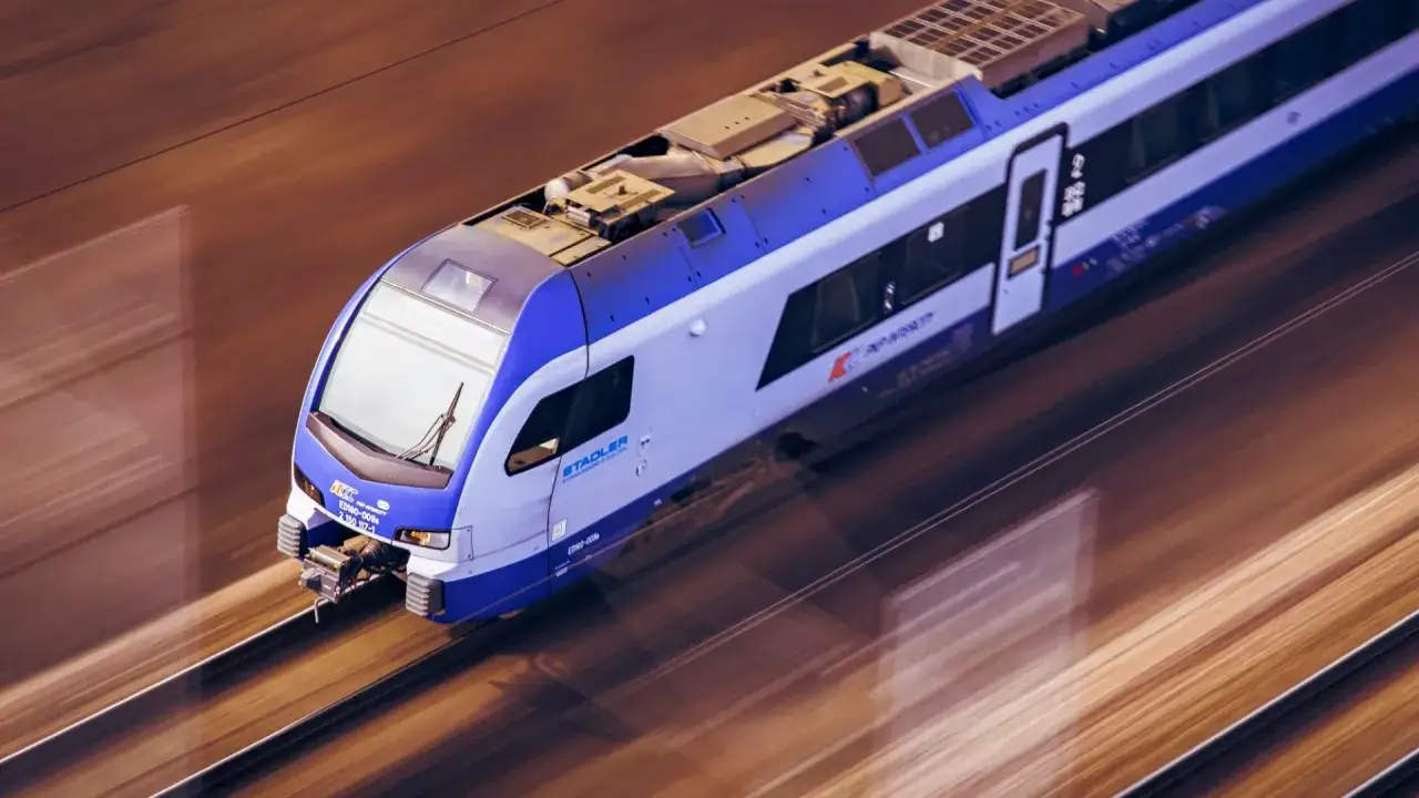Nowoczesny pociąg PKP Intercity mknie po torach, tworząc wrażenie ruchu. Mehoffer pociąg w ruchu.