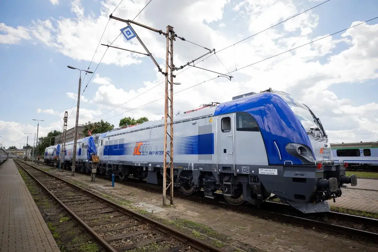 Nowy lubuszanin pociąg PKP Intercity stoi na torach pod błękitnym niebem.