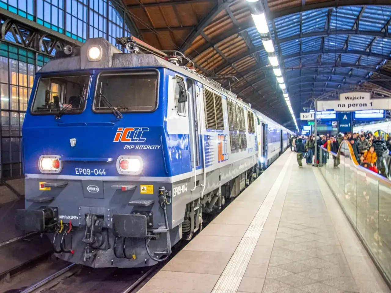 Niebieska lokomotywa PKP Intercity EP09-044 na peronie, gotowa do podróży z Łodzi Kaliskiej do Kołobrzegu.