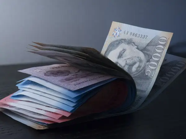 Stos banknotów, w tym 20 000 forintów, symbolizuje walutę w Budapeszcie.